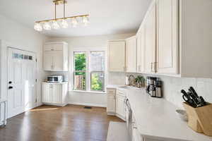 Kitchen with extended cabinetry, tile backsplash, quartz counters