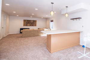 Full length family room in the basement with recessed lighting and a breakfast bar.