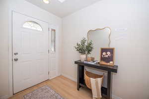 Entrance foyer featuring laminate flooring and as skylight.