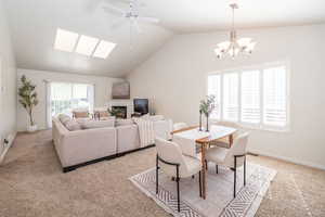 Dining space with ceiling fan, skylights, and a fireplace.
