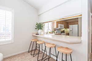 Breakfast bar area with carpet and louvered shutters.