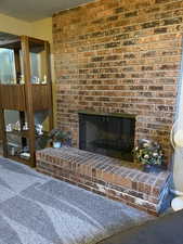Detailed view of a brick fireplace and carpet flooring