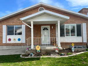 View of front of home featuring a porch and brick siding