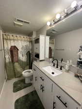 Bathroom featuring vanity, curtained shower, a textured ceiling, and light tile patterned floors
