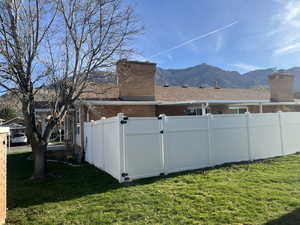View of yard featuring a mountain view vinyl fence with gate