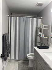 Full bath with vanity, a textured ceiling, and shower / tub combo