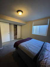 Bedroom featuring a textured ceiling, carpet flooring, and a closet