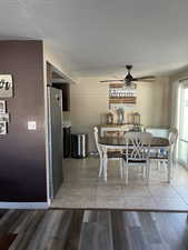 Dining room featuring a ceiling fan, a textured ceiling, and light wood-style floors