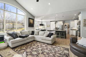 Living room featuring arched walkways, light wood-style floors, and recessed lighting