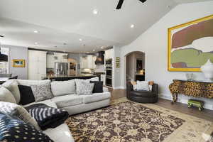 Living room featuring arched walkways, a ceiling fan, light wood finished floors, and recessed lighting