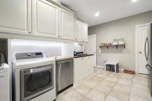 Laundry room featuring independent washer and dryer, recessed lighting, and light tile patterned floors