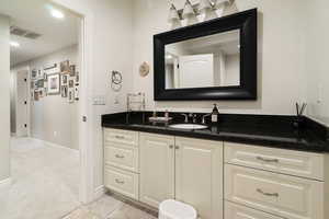 Bathroom with vanity, recessed lighting, and light colored carpet