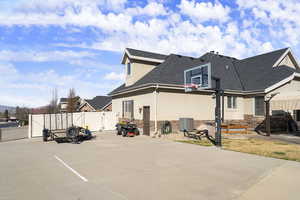 View of parking with basketball court and a gate