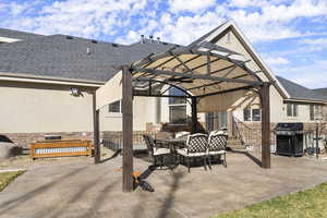 View of patio with outdoor dining area, a grill, and a gazebo