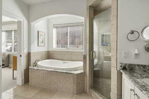 Full bath featuring a stall shower, vanity, plenty of natural light, and a bath
