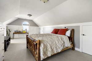 Bedroom featuring light colored carpet and a textured ceiling