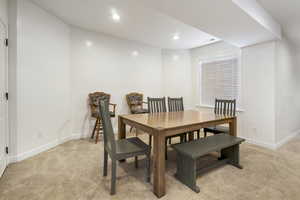 Dining room with light colored carpet and recessed lighting