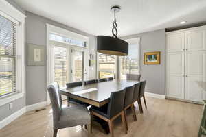 Dining area featuring light wood-style flooring and a textured ceiling