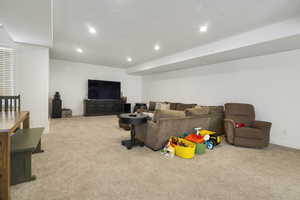 Living area with light carpet and recessed lighting