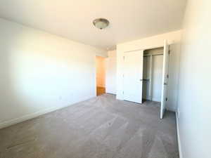 Unfurnished bedroom featuring carpet and a closet