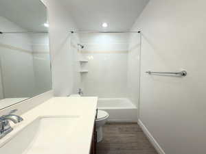 Full bath featuring vanity, dark wood-type flooring, and tub / shower combination