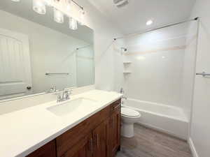 Full bath featuring vanity, light wood-style flooring, and shower / bath combination