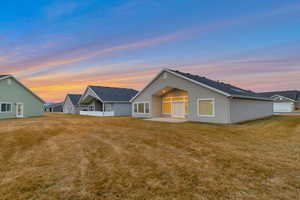 View of front of home with a patio area, a front yard, and stucco siding