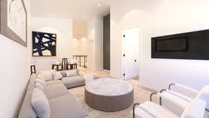 Living area featuring light wood finished floors, arched walkways, recessed lighting, and a high ceiling