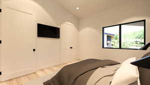 Bedroom with light wood finished floors, recessed lighting, and lofted ceiling