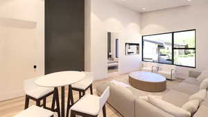 Living room featuring light wood finished floors, recessed lighting, and a high ceiling