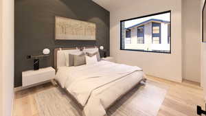 Bedroom featuring light wood-style floors and an accent wall