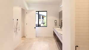 Full bath featuring double vanity and light tile patterned floors