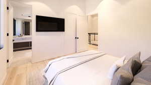 Bedroom featuring light wood-style flooring and connected bathroom