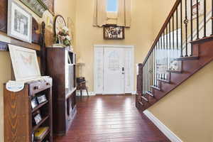 Entrance foyer featuring dark wood-style floors and a high ceiling