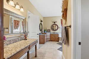 Bathroom featuring two vanities and light tile patterned flooring