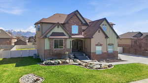 View of front of house with stucco siding, stone siding, and a mountain view