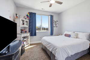 Carpeted bedroom with baseboards and a ceiling fan