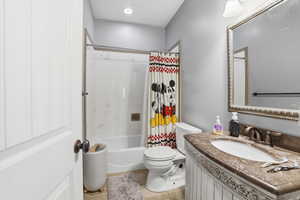 Bathroom with vanity, shower / tub combo, and light tile patterned floors