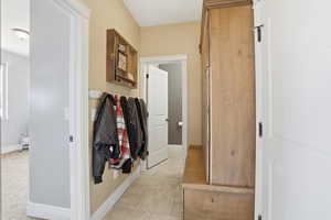 Hallway with light tile patterned floors and baseboards