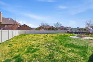 Fenced backyard with a patio, a fire pit, and a residential view
