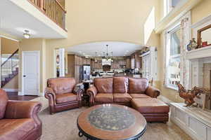 Living area featuring ornate columns, plenty of natural light, arched walkways, recessed lighting, and a high ceiling