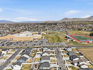 Aerial view of property and surrounding area with a mountainous background and nearby suburban area
