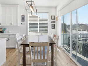 Dining area featuring light wood-type flooring and hanging lights