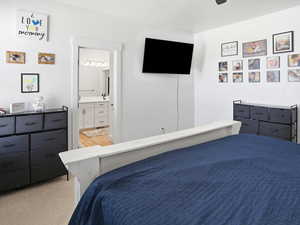 Bedroom featuring light carpet, connected bathroom, and ceiling fan