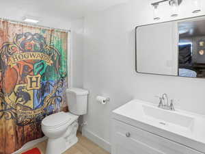 Bathroom featuring vanity, curtained shower, and light wood-type flooring