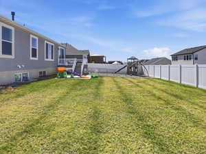 Fenced backyard with a deck and a playground