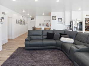 Living room with light wood-style floors and recessed lighting