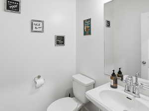 Half bath featuring toilet and a sink