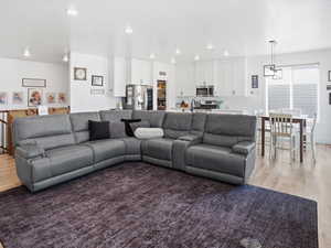 Living area with light wood-style floors and recessed lighting