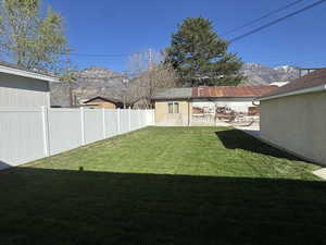 Fenced backyard featuring a mountain view and an outdoor structure